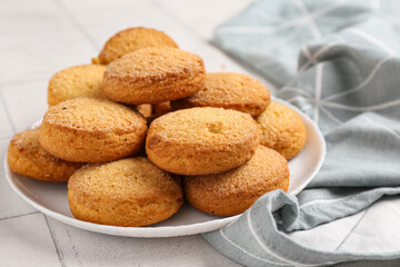 Plate with sweet cookies on white tile background, closeup