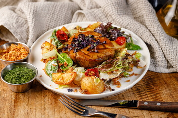 Plate of food with meat and vegetables on a wooden table