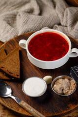 Traditional soup served with bread and toppings on a wooden table