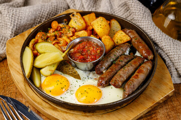 Sausage and eggs served with vegetables and potatoes at breakfast time