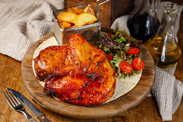 Grilled chicken wings served with salad and potatoes in a restaurant