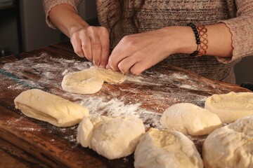 In a cozy Romanian kitchen, hands skillfully shape dough into moldavian mucenici and braided...