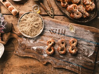 In a cozy Romanian kitchen, steam rises from a clay oven as golden mucenici and braided colaci cool on an old wooden table, framed by whitewashed walls and soft natural light