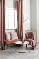 Stylish interior of living room with soft bench near window