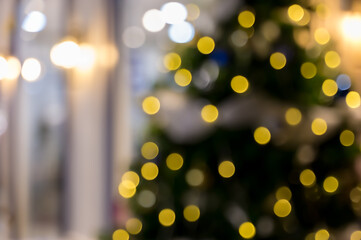 Defocused Christmas tree with golden yellow bokeh lights for festive seasonal celebration abstract background