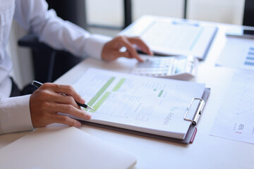 Businessman working in office reading documents analyze data for project planning.