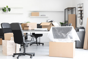 Interior of light office with cardboard boxes on moving day