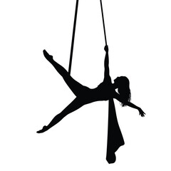 Silhouette of an aerialist performing a graceful pose on hanging ropes