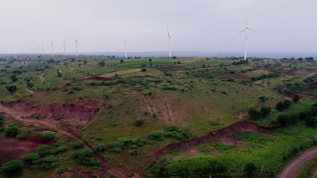 windmills with Greenery and farming lands. day time, jib shot, drone shot, 4k.