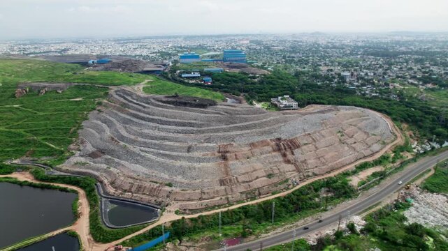 Aerial view of balaji nagar Dumping yard with cityscape and greenery. day time, semi orbit shot, drone shot, 4k.