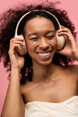 Obraz premium Joyful young woman enjoying music while wearing stylish headphones in a vibrant setting