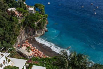 Top view from Amalfi coast of private beach of Tyrrhenian Sea with blue azure water.