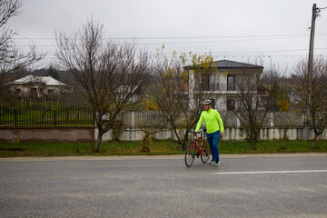 A middle-aged man takes his bike for a ride in the morning.