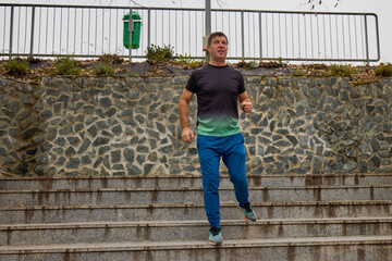 A middle-aged man does morning warm-up exercises and runs.