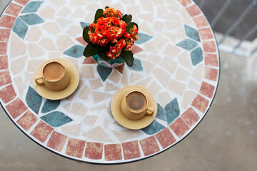 Close-up top view of two small cups of coffee on table.