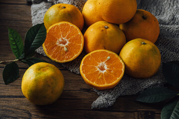 Fresh Oranges on Wooden Table with Green Leaves in Natural Light