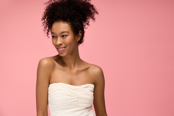 Joy and elegance captured in a young womans radiant smile against a soft pink backdrop