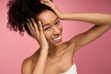 Fototapeta premium Bright smile of a young woman under soft pink lights, expressing joy and confidence