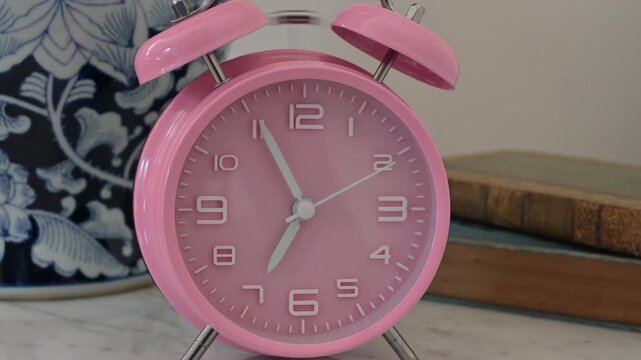 Pink alarm clock on bedside  table 