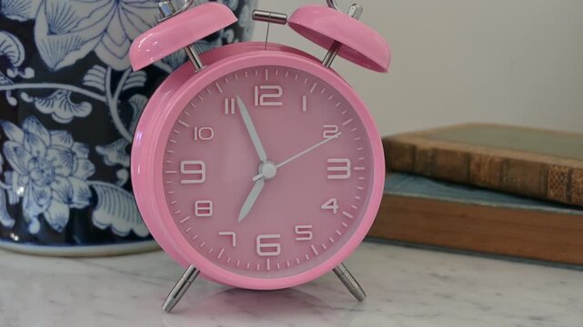 Pink alarm clock on bedside  table 