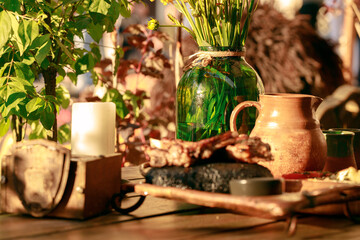 still life scene alchemy potion dishes glass and jug and jar with grass sunny garden table