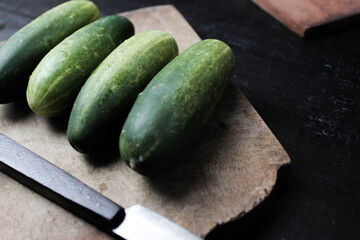 cucumber on cutting board with black background