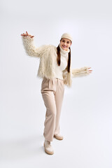 Charming teenager showcases stylish winter fashion in bright studio setting