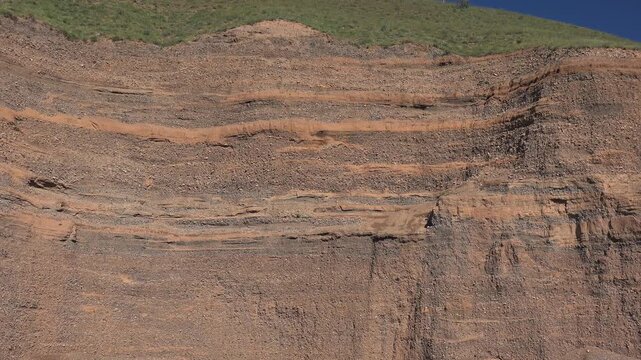 Different forms in cross section of soil horizon layers revealing texture and structure. Natural earth profile shows stratified sediments and geological patterns in ground materials.