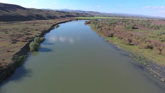 Aerial view of still waters of the Nile River flowing across flat plains of Africa. Calm river surface defines vast geography linking Sudan Ethiopia Egypt and Central African regions.