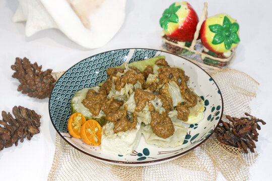 A plate of Sundanese cuisine&mdash;known as siomay Bandung or baso tahu&mdash;is set on a placemat. The dish includes boiled potatoes, fish dumplings, tofu, bitter melon, and a rich peanut sauce.