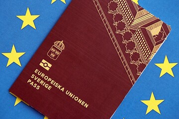 Swedish biometrical passport on European Union flag background. Concept of citizenship of Sweden