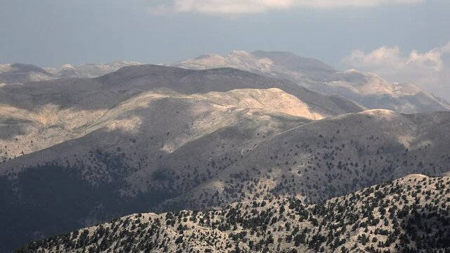 Aerial view of treeless rocky slopes across the Zagros Mountains in Iran. Vast barren highlands reveal raw stony textures and arid mountain geology.