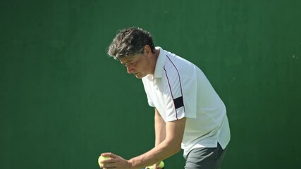 Mature padel tennis player serving ball