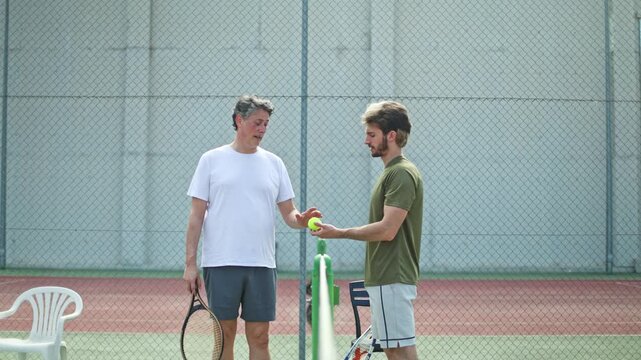 Father and son greeting each other on a tennis court