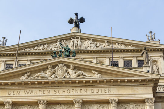 View of the Alte Oper building with its elaborate sculptural details and inscription 'DEM WAHREN SCHOENEN GUTEN' under a clear sky, Frankfurt am Main, Hessen, Germany.