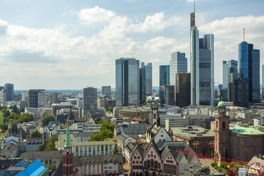 View of modern skyscrapers pierce the sky above historic buildings, a vibrant contrast of old and new, bathed in soft daylight, Frankfurt am Main, Hessen, Germany.