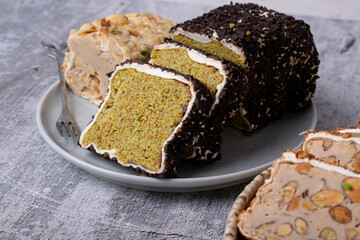 Sliced ​​Turkish delight roll with creamy pistachio filling sprinkled with crushed chocolate. Local name: fistikli fitil lokum. Close-up