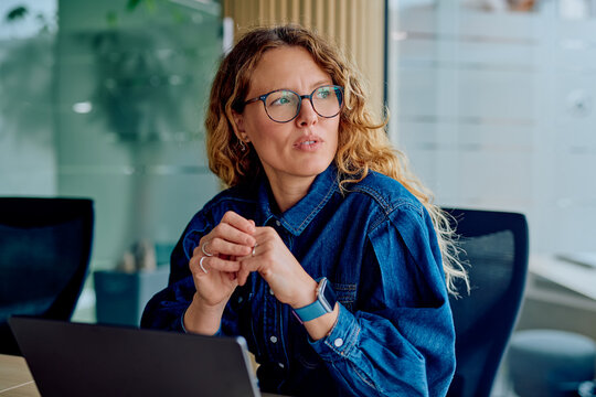 Thoughtful woman concentrating during an office meeting, brainstorming ideas, or listening actively with a focused expression