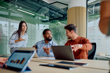 Diverse business professionals having a meeting, discussing strategy and financial data, collaborating in a modern office environment
