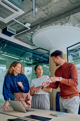 Three diverse business people collaborating, sharing ideas, and planning strategies during a team meeting in a contemporary workspace © we.bond.creations