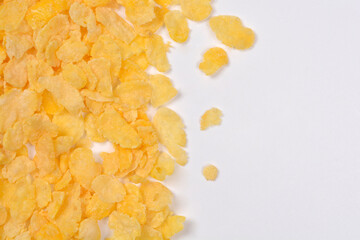 Golden corn flakes fill the left side of the frame, leaving a large blank white space on the right for copy