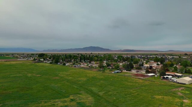 Flying Drone Over Beautiful Green Grass Rural American Fields and Neighborhood in Syracuse Utah on Cloudy Overcast Rainy Spring Day