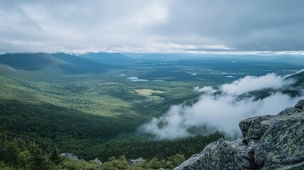 View from rocky mountaintop overlooking wide green valley under a bright blue sky with large cumulus clouds. Sunlight highlights treetops and distant farmlands. Generative by AI
