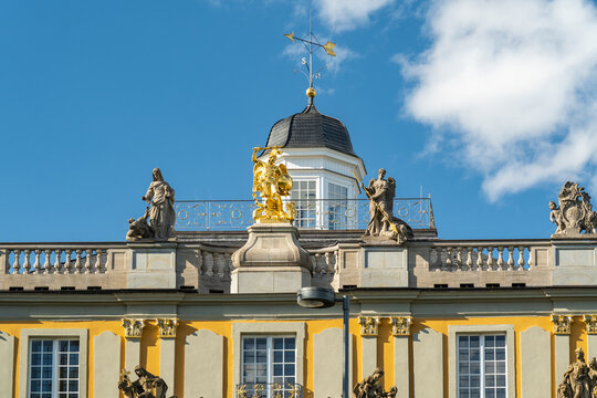 View of ornate statues standing proudly atop a golden-trimmed koblenzer Tor building under a bright blue sky, Bonn, North Rhine-Westphalia, Germany.
