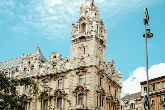 View of ornate architecture rises against a bright blue sky, with intricate details catching the sunlight, creating a stunning visual contrast, Budapest, Hungary.
