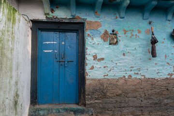 A village house made of mud and stone with wooden doors.