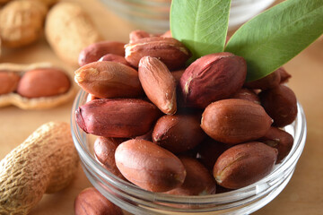 Detail of peeled peanuts in glass bowl on a white table