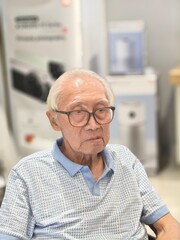 Close-Up Portrait of a Distinguished Elderly Asian Man with Eyeglasses
