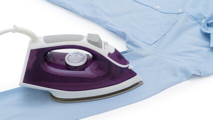 beside view of purple electric iron placed on light blue shirt while ironing