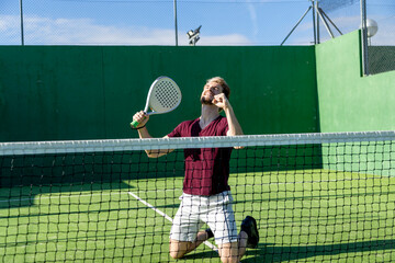 Padel player celebrating victory on green court